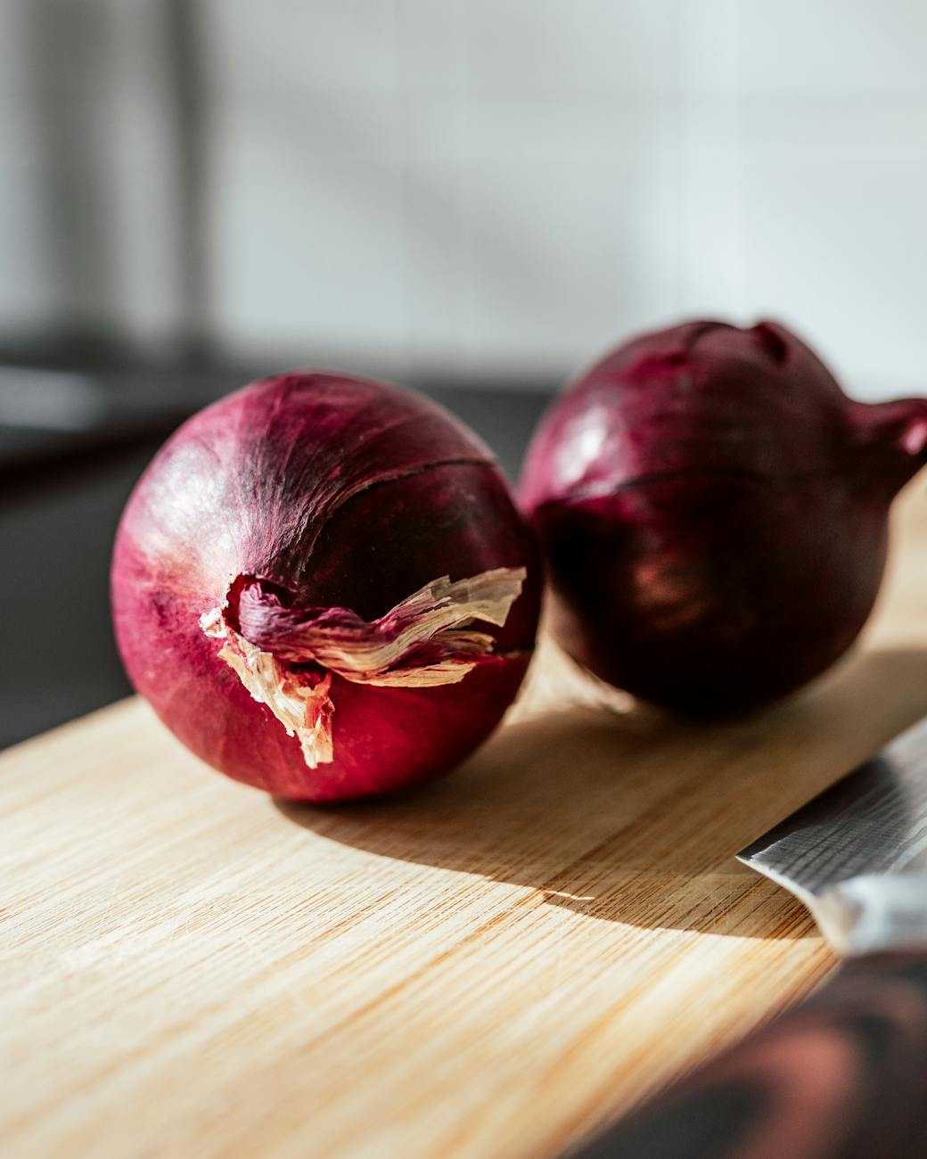 close up shot of onions on wooden chopping board
