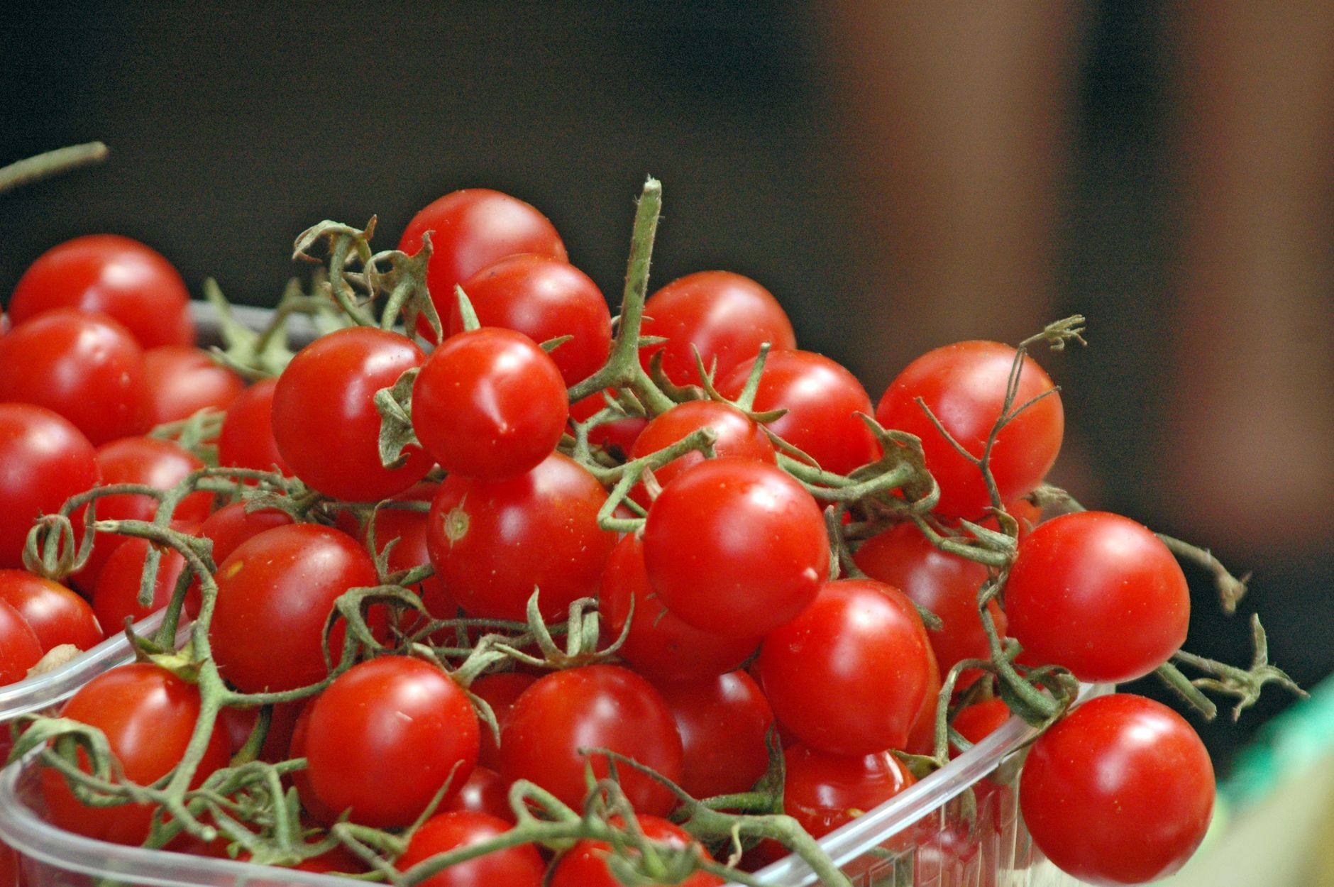 a red cherry tomatoes on a plastic crate